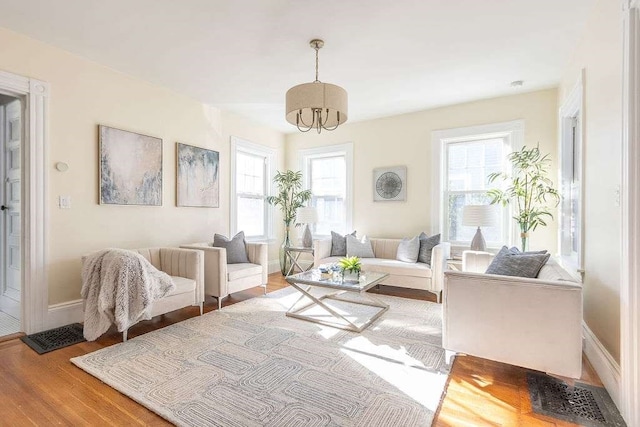 sitting room featuring a chandelier, hardwood / wood-style flooring, and a healthy amount of sunlight