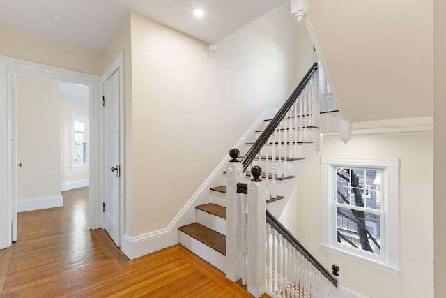 stairway with a healthy amount of sunlight and wood-type flooring