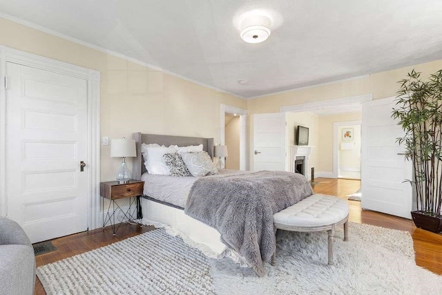 bedroom with wood-type flooring and crown molding