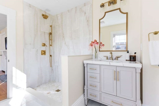 bathroom featuring a tile shower, vanity, and hardwood / wood-style flooring