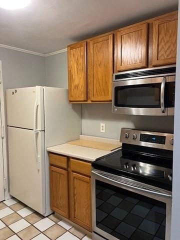 3 Village Rock Ln Unit 1, Natick, MA 01760 - kitchen with appliances with stainless steel finishes, ornamental molding, light countertops, brown cabinetry, and light tile patterned floors