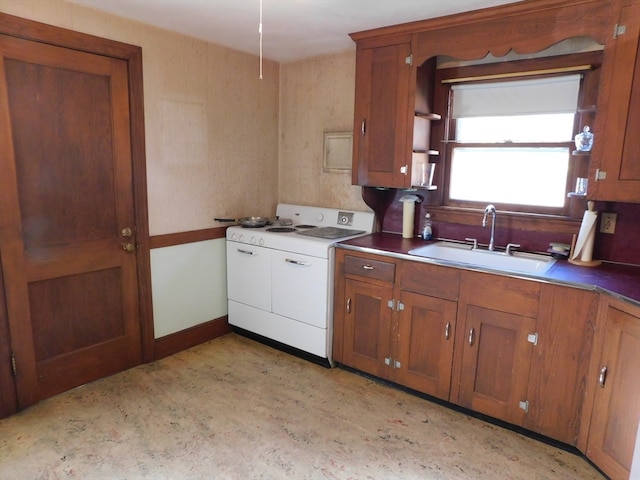 kitchen with washer / clothes dryer, sink, and white stove