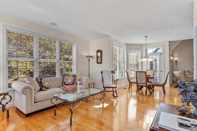 living room with light hardwood / wood-style flooring and a chandelier