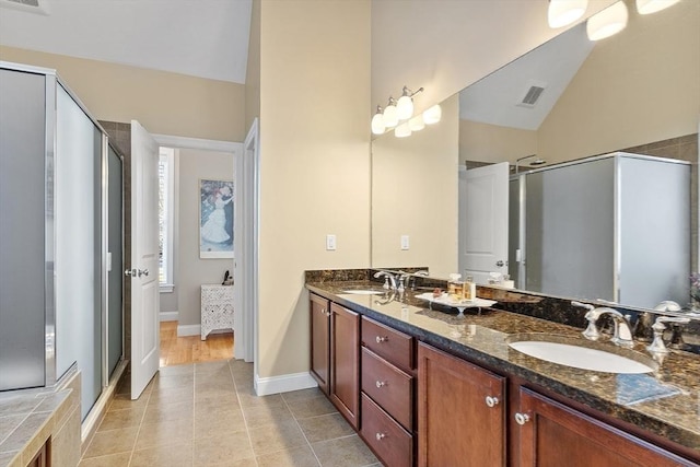 bathroom with an enclosed shower, vaulted ceiling, tile patterned floors, and vanity