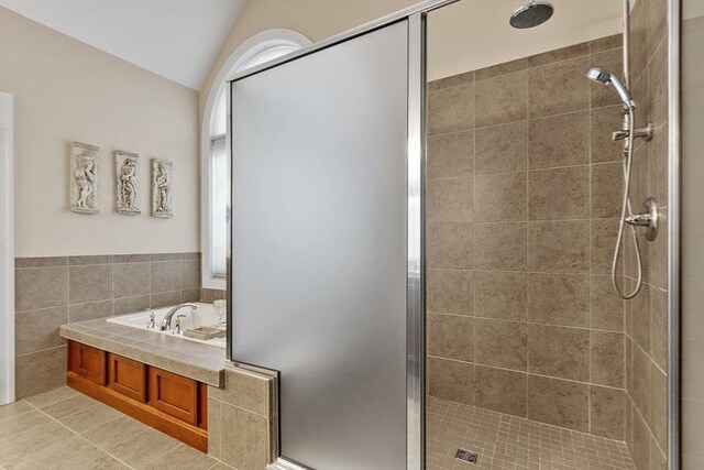 bathroom featuring tile patterned flooring, tile walls, vaulted ceiling, and plus walk in shower