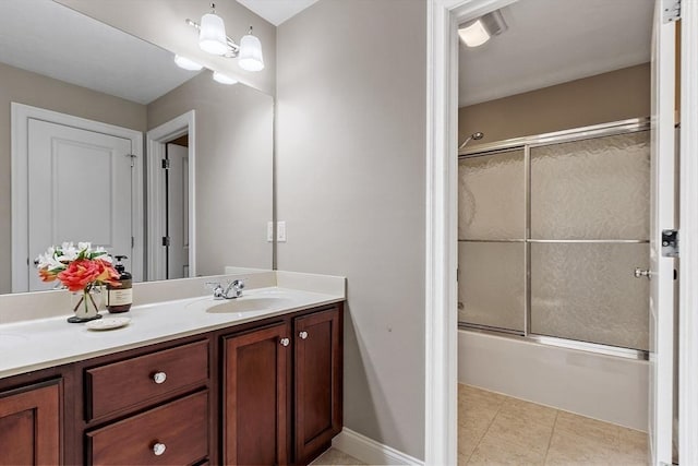 bathroom featuring enclosed tub / shower combo, tile patterned floors, and vanity