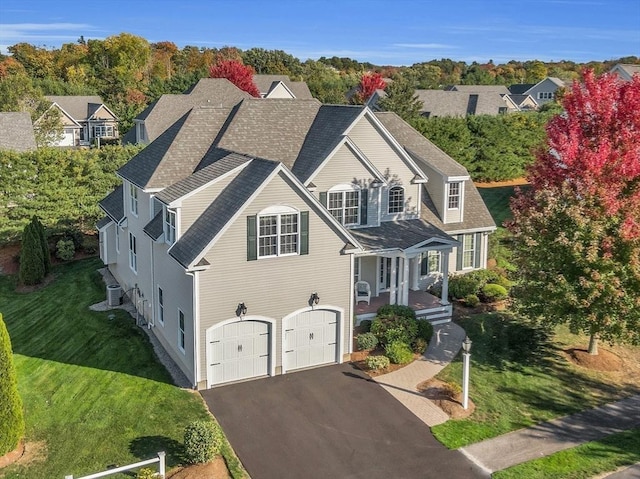 view of front of home with a garage, central AC, and a front lawn