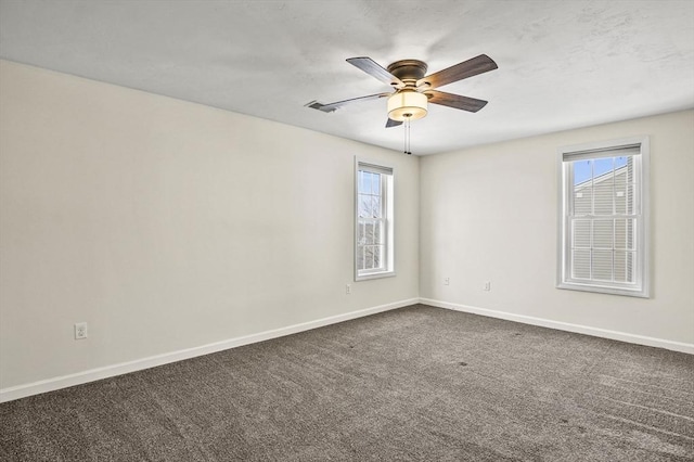 empty room featuring carpet flooring, ceiling fan, visible vents, and baseboards