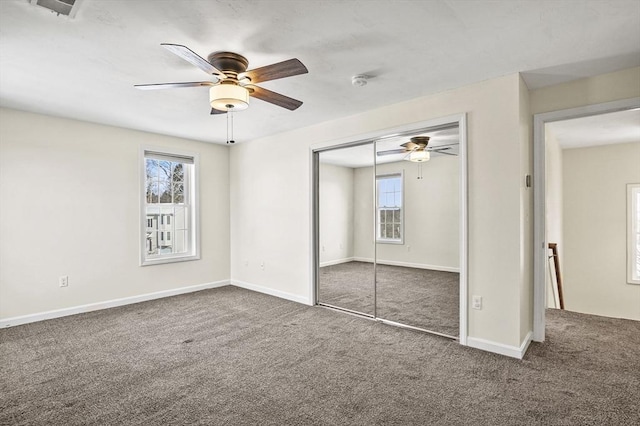 unfurnished bedroom with carpet, a closet, ceiling fan, and baseboards