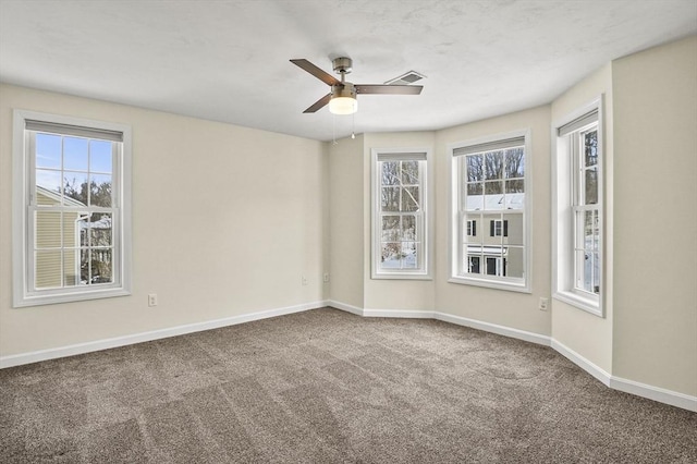 empty room with carpet, visible vents, baseboards, and ceiling fan