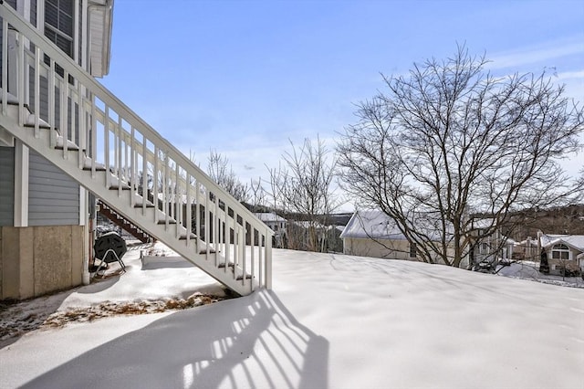 yard layered in snow featuring stairs