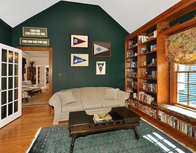 living room with french doors, wood finished floors, and vaulted ceiling