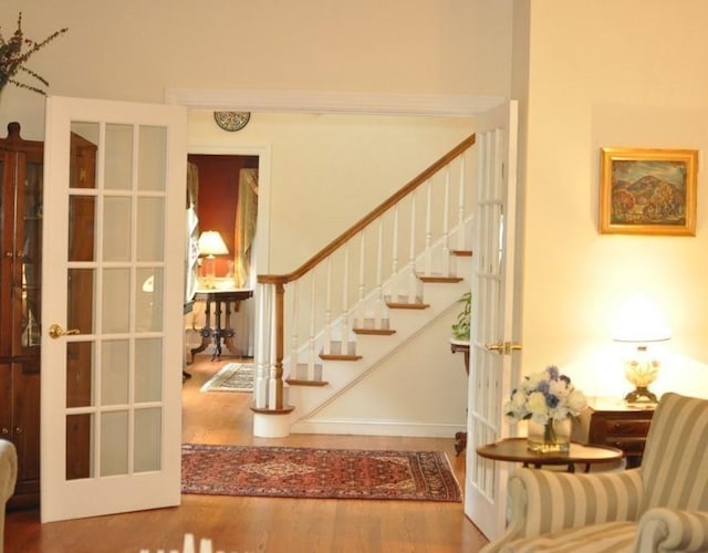 staircase featuring french doors and wood finished floors