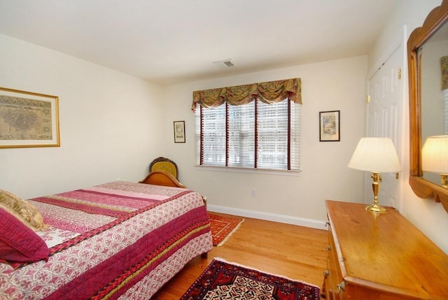 bedroom with baseboards and wood finished floors