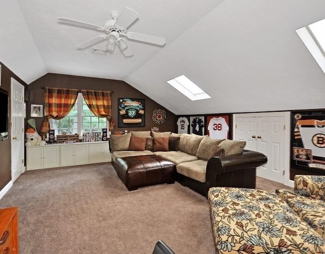 living room with vaulted ceiling with skylight, carpet, and ceiling fan