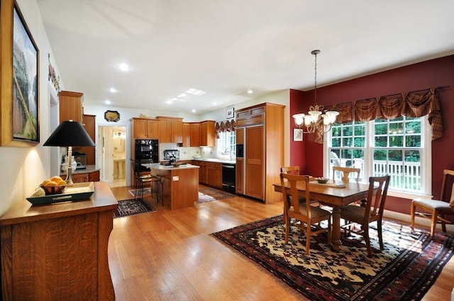 dining space featuring a notable chandelier, light wood-style floors, recessed lighting, and a wealth of natural light