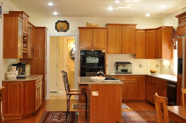 kitchen featuring decorative backsplash, brown cabinets, a kitchen island, and dobule oven black