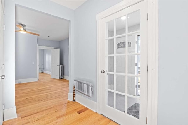 corridor with wood-type flooring and radiator