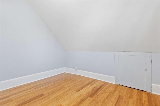 additional living space featuring lofted ceiling and hardwood / wood-style flooring