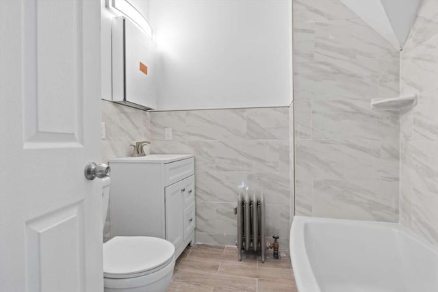 full bathroom featuring radiator, bathtub / shower combination, vanity, vaulted ceiling, and toilet