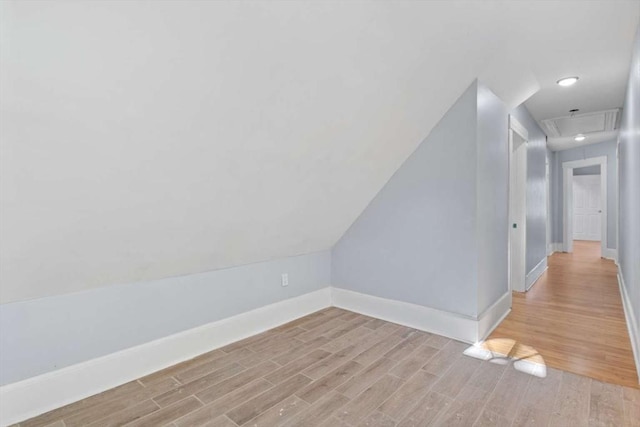 bonus room with light hardwood / wood-style floors and vaulted ceiling