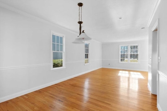 spare room with light wood finished floors, baseboards, and ornamental molding