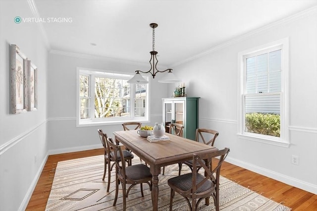 dining area with crown molding, baseboards, and wood finished floors