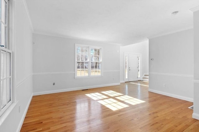 unfurnished room with baseboards, crown molding, stairs, and light wood finished floors