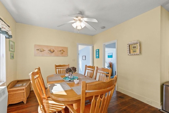 dining space featuring a ceiling fan, baseboards, and dark wood-style flooring