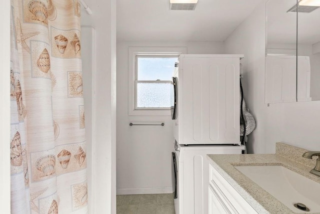 full bath with stacked washer / dryer, visible vents, baseboards, a shower with shower curtain, and vanity