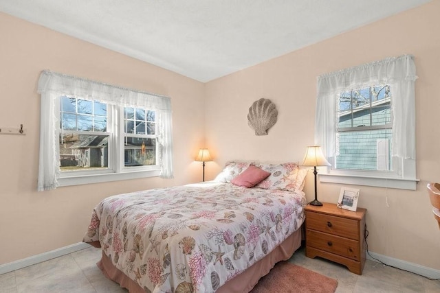 bedroom with baseboards and multiple windows