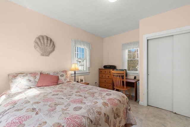 bedroom with multiple windows, a closet, and light tile patterned floors