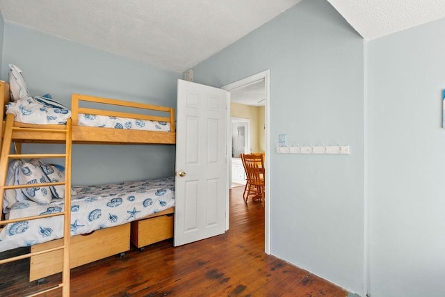 bedroom with a textured ceiling and wood-type flooring