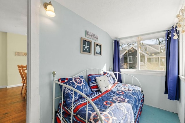 bedroom featuring lofted ceiling and wood finished floors