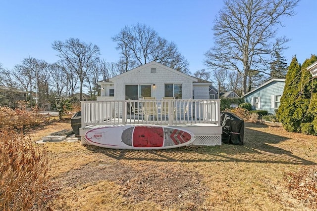 rear view of property with a lawn and a wooden deck