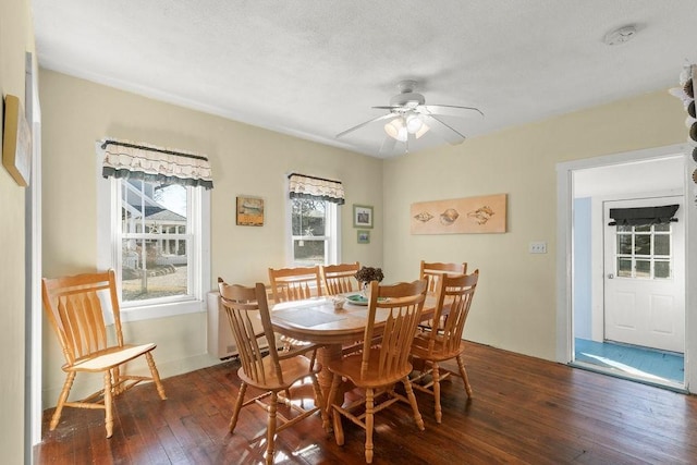 dining area with dark wood finished floors and a ceiling fan