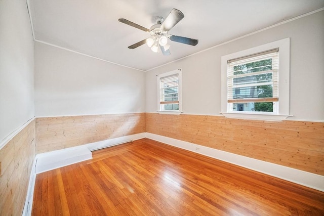 empty room with ornamental molding, hardwood / wood-style floors, and ceiling fan