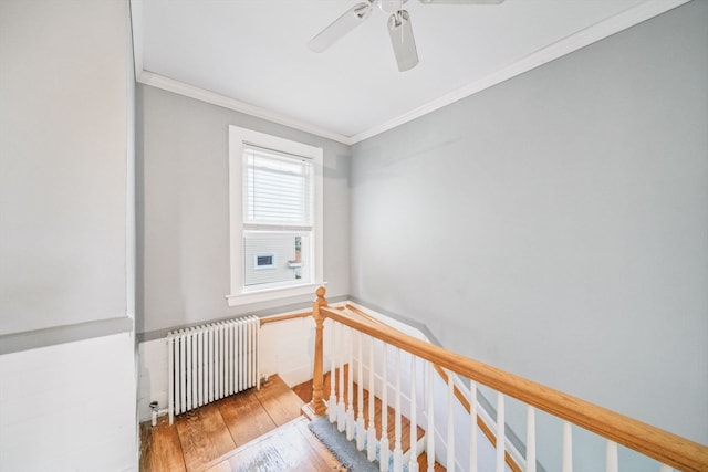 interior space with radiator heating unit, ornamental molding, and wood-type flooring