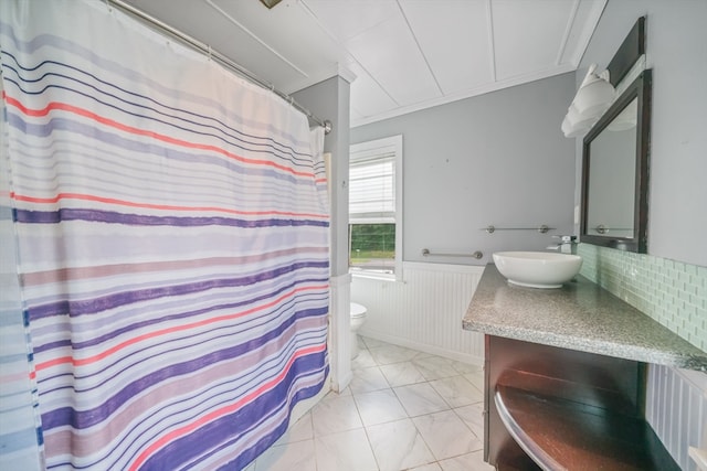 bathroom with vanity, tasteful backsplash, crown molding, tile patterned floors, and toilet