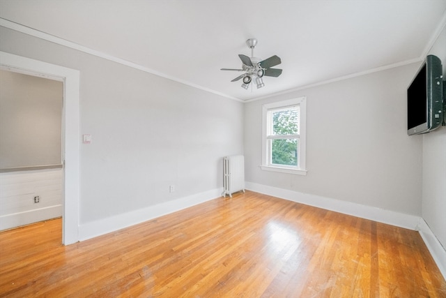 empty room featuring light hardwood / wood-style floors, ornamental molding, ceiling fan, and radiator heating unit