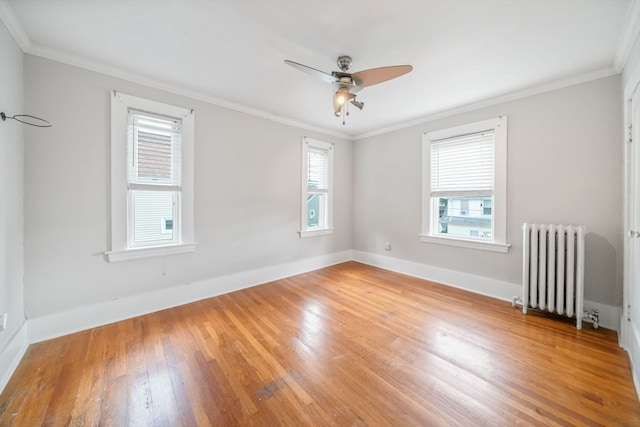 spare room with radiator heating unit, ceiling fan, light hardwood / wood-style floors, and ornamental molding