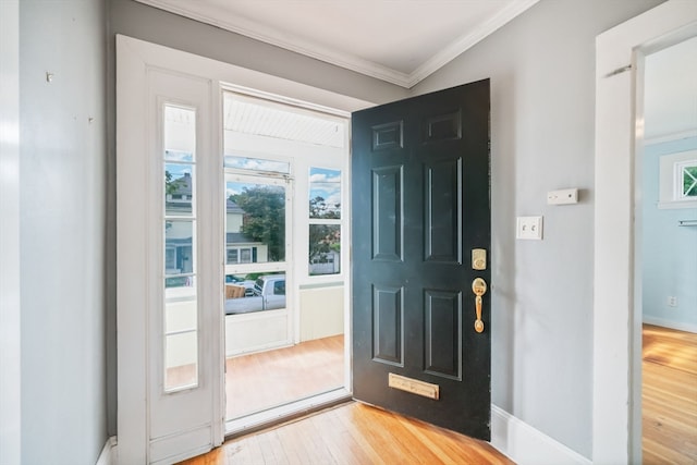 foyer with light hardwood / wood-style flooring and crown molding