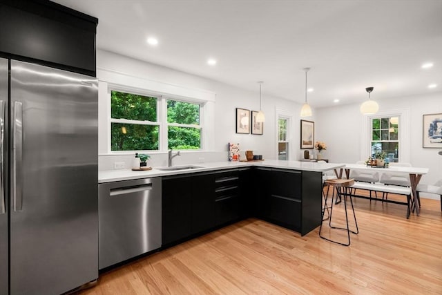 22 Carter St, Newton, MA 02460 - kitchen with stainless steel appliances, dark cabinets, a sink, light countertops, and recessed lighting