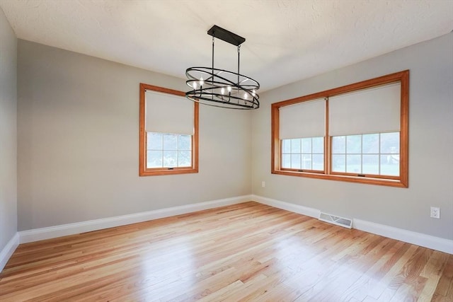 47 Forest St, Franklin, MA 02038 - empty room with plenty of natural light, a chandelier, light wood-type flooring, and baseboards