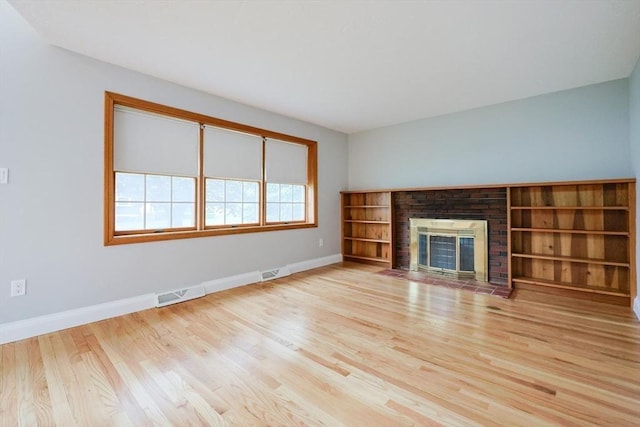 47 Forest St, Franklin, MA 02038 - unfurnished living room with wood finished floors, baseboards, and a brick fireplace