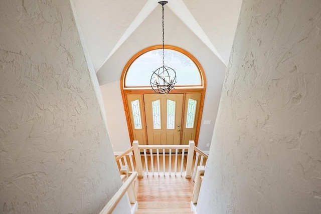 47 Forest St, Franklin, MA 02038 - entryway featuring a chandelier, lofted ceiling, light wood-style flooring, and a textured wall