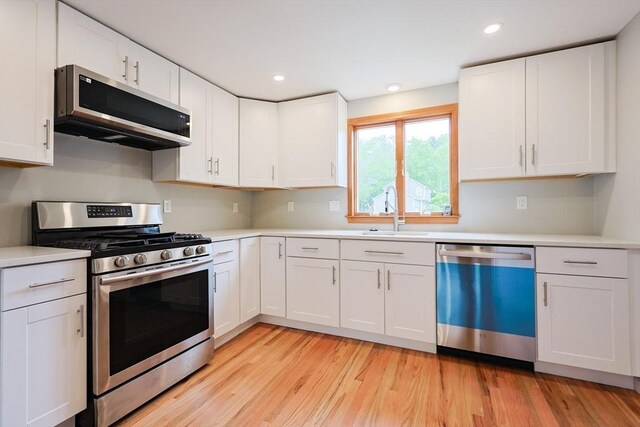 47 Forest St, Franklin, MA 02038 - kitchen featuring stainless steel appliances, a sink, light countertops, white cabinetry, and recessed lighting