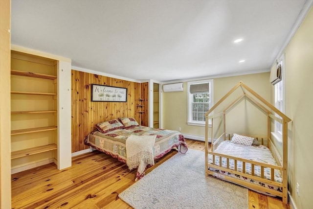 274 Morton Rd, Chatham, MA 02659 - bedroom with crown molding, wood walls, wood finished floors, an AC wall unit, and baseboards
