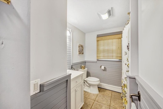 274 Morton Rd, Chatham, MA 02659 - bathroom featuring wainscoting, a baseboard radiator, toilet, vanity, and tile patterned floors