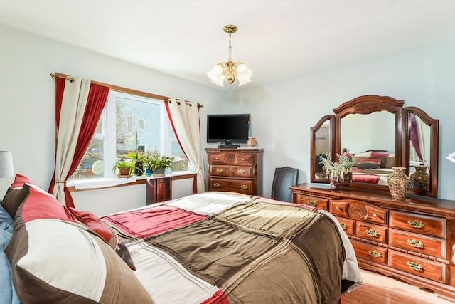 bedroom featuring an inviting chandelier and light hardwood / wood-style flooring